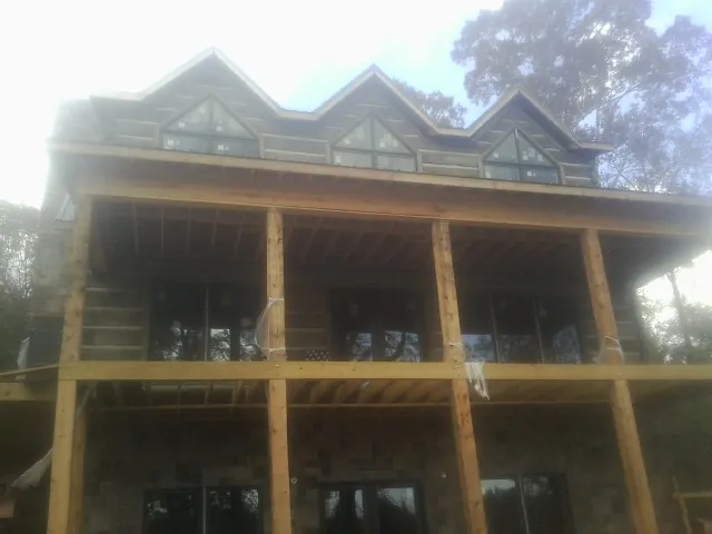 Dormers and porch framing on a large log home under construction — Roof Coating work by our crew in Gravel Switch
