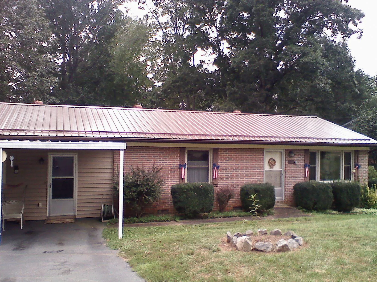 Bronze metal roof and carport on a brick ranch home — Roof Repair work by our crew in Gravel Switch